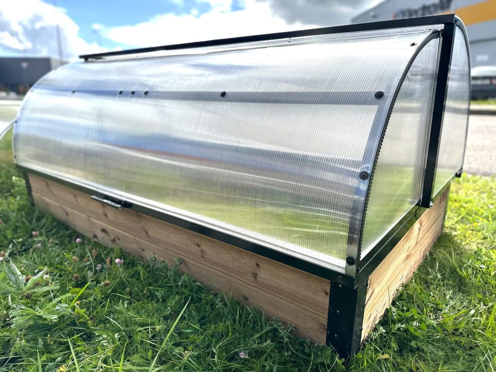 Matala pieni kasvihuone nurmikolla